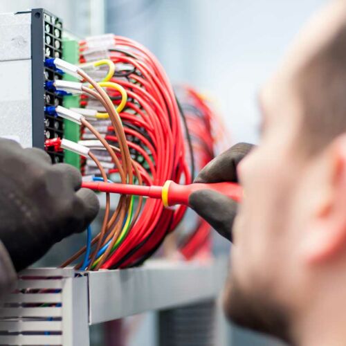Elektriker arbeitet an Schaltkasten